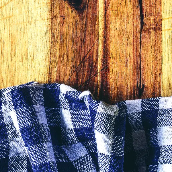 Getting rid of clutter by using simple items. A checkered cloth rests on a wooden cutting board.