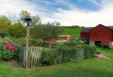 fenced in garden with red barn in background