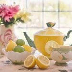 tea pot, tea cup, lemons, and flowers on table