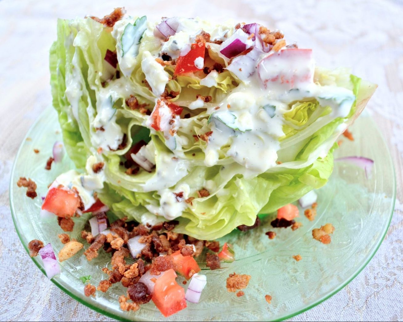 wedge salad with tomato, bacon, onion, dressing