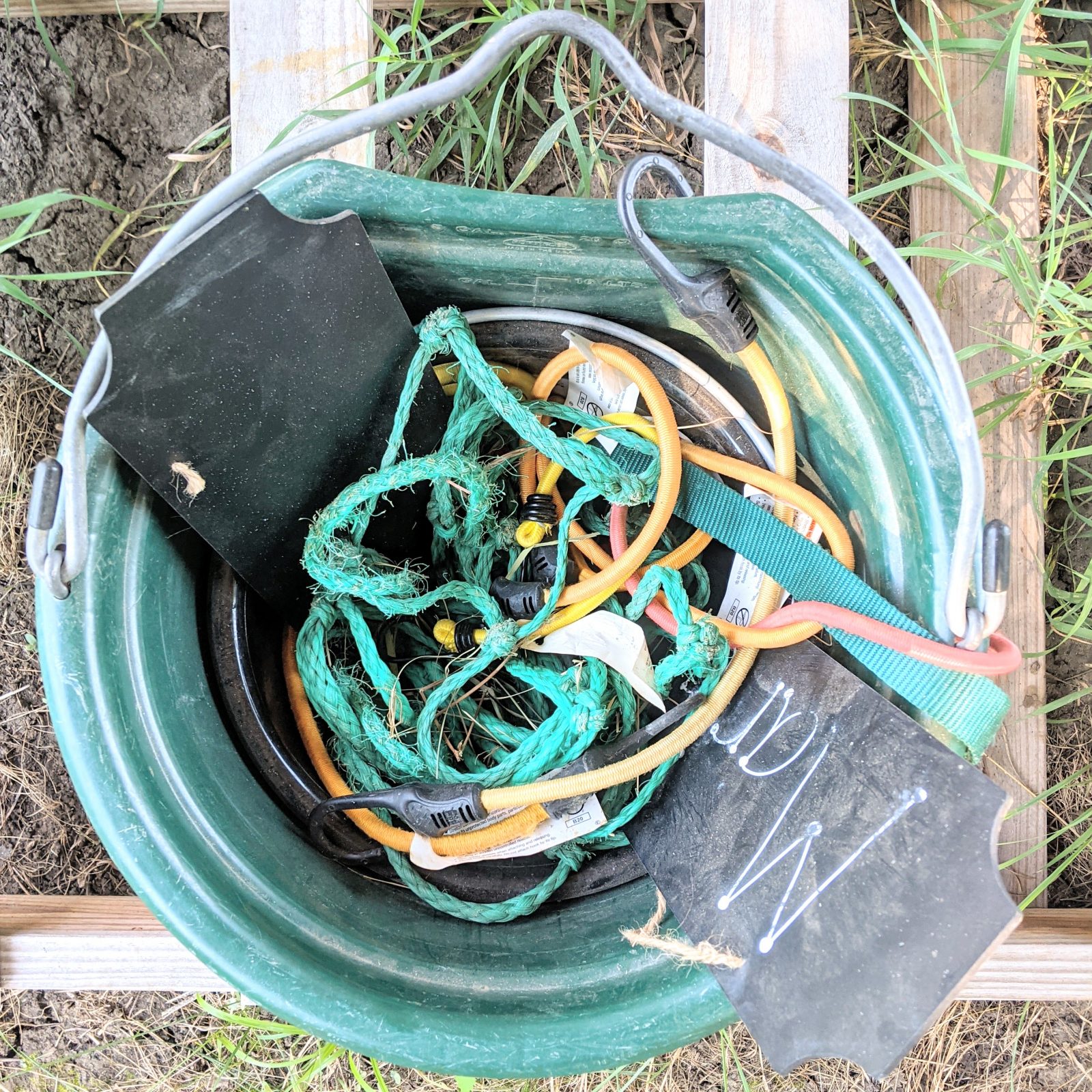 bucket with sign, bungee cords, hay net