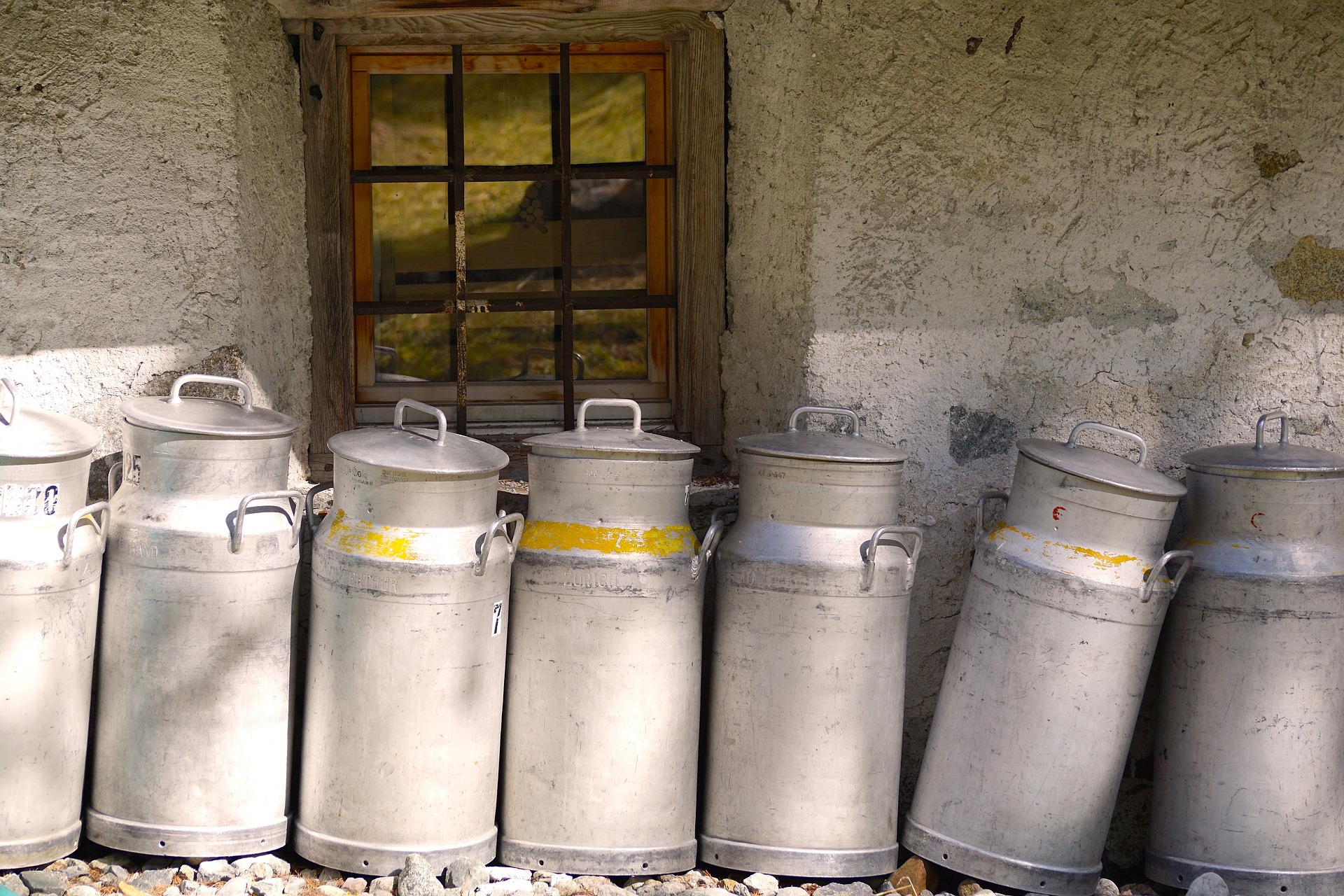 antique milk cans against wall